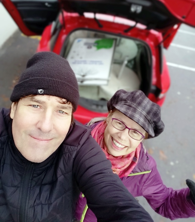 Dominik und Eliane vor dem Auto mit den eingeladenen Plakaten und Plakatständer der Baumführung im Industriequartier Zürich, welche in die Winterlager gebracht werden